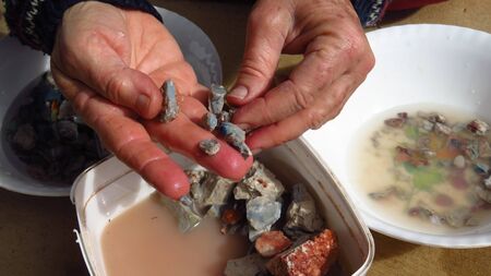 Miner Cleaning Stones in Search or Opal