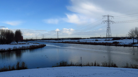 Winter Landscape with Canal Intersection Covered in Snowの写真素材