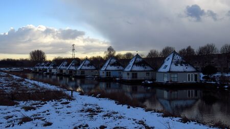 Beautiful Snow Covered Pyramid Shaped Houses on Canalの写真素材