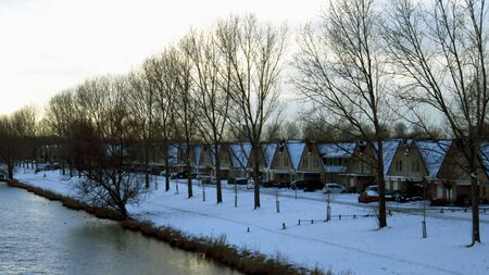 Dutch Houses Along Canal Covered in Snow During Winterの写真素材