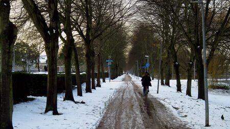 Riding Bicycle on Bicycle Path Covered in Snow and Ice During Winterの写真素材
