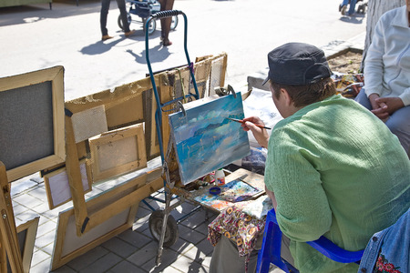 CRIMEA, FEODOSIA - May 25.2014: Street artist sells his paintings and drawing newのeditorial素材