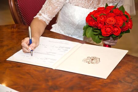 Marriage. Bride puts his signature to the documentの写真素材
