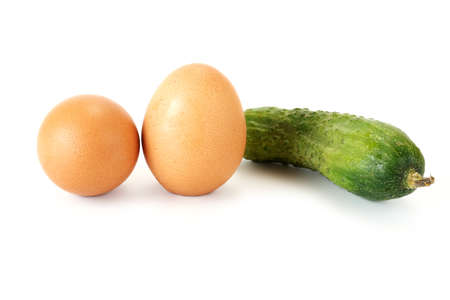 Green cucumber and chicken egg are isolated on a white backgroundの写真素材