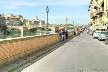 FLORENCE, ITALY - October 07.2011: Tourists and townspeople walking  on the embankment along of the river Arno in city Florenceのeditorial素材