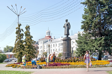 BELGOROD, RUSSIA - August 30.2016: Brigade of workers engage in planting trees and shrubs of municipal service work on a flowerbed next to a monument to general Apanasenkoのeditorial素材
