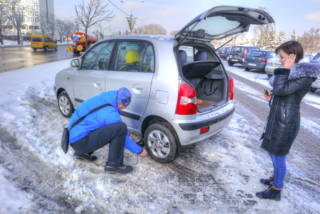MINSK, REPUBLIC OF BELARUS - January 16.2017: Man changes a leaky tire on my personal carのeditorial素材