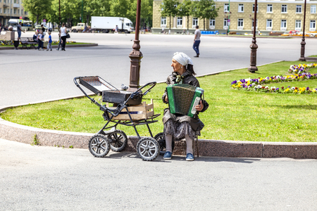 VELIKY NOVGOROD, RUSSIA - June 03.2019: An elderly woman earns her living by playing the squeezeboxのeditorial素材
