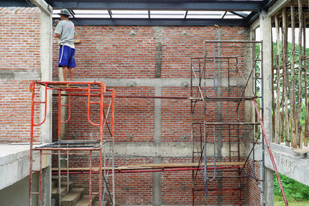 Workers installing bricklayer and plastering the cement texture on the wallのeditorial素材