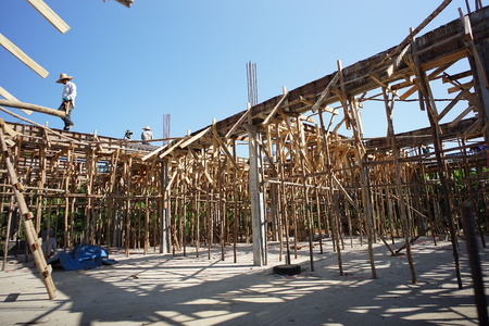 Wooden structure support in the house construction with workers and clear blue skyのeditorial素材