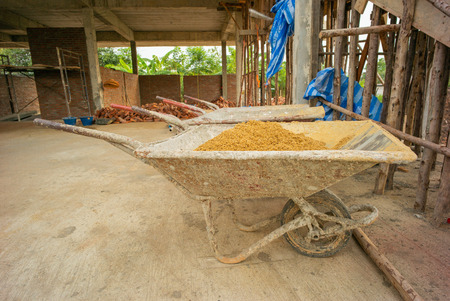 The sand in the dirty steel cart for delivering around the site at the house unser constructionの写真素材