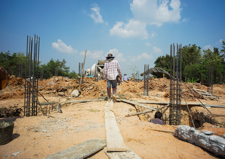 Workers carrys the cement cart and pour in the foundation of house under construction.のeditorial素材