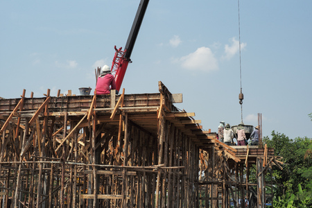 Workers carrying the cement container to pour into the mold at the house under constrution. Teamwork and spirit conceptのeditorial素材
