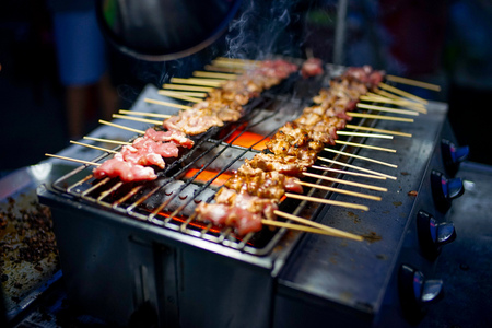 Traditional grilled pork and meat by gas system grill. Delicious street food in Thailandの写真素材