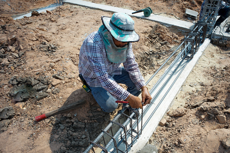Worker doing the steelwork for reinforcement of the concrete structure at the construction siteの写真素材
