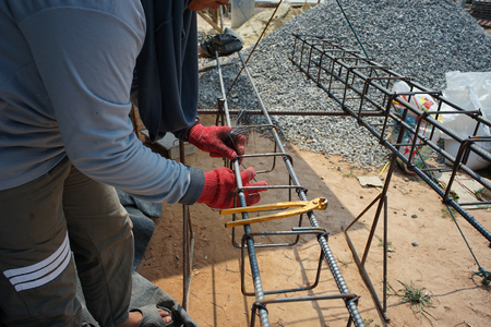 Worker doing the steelwork for reinforcement of the concrete structure at the construction siteの写真素材