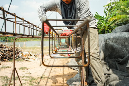 Worker doing the steelwork for reinforcement of the concrete structure at the construction siteの写真素材