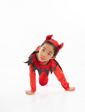 Portrait Asian little cute girl in evil costume for Halloween festival with pumpkinの写真素材