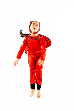 Portrait Asian little cute girl in evil costume for Halloween festival with pumpkinの写真素材