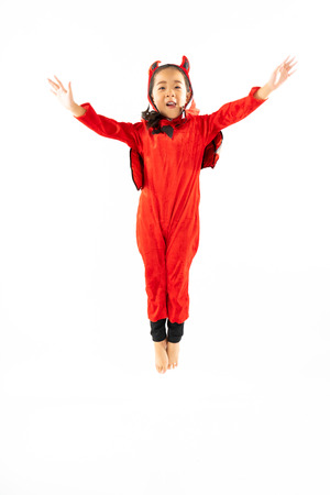 Portrait Asian little cute girl in evil costume for Halloween festival with pumpkinの写真素材