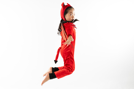 Portrait Asian little cute girl in evil costume for Halloween festival with pumpkinの写真素材