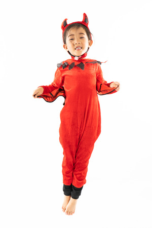 Portrait Asian little cute girl in evil costume for Halloween festival with pumpkinの写真素材