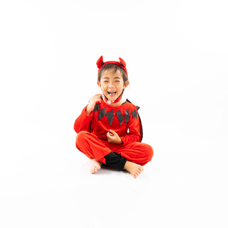 Portrait Asian little cute girl in evil costume for Halloween festival with pumpkinの写真素材