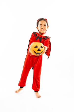 Portrait Asian little cute girl in evil costume for Halloween festival with pumpkinの写真素材