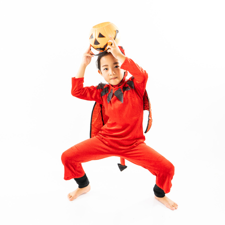 Portrait Asian little cute girl in evil costume for Halloween festival with pumpkinの写真素材