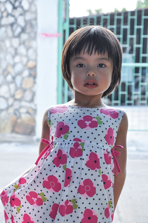 Portrait Asian little girl looking at the camera with sunlight in backgroundの写真素材
