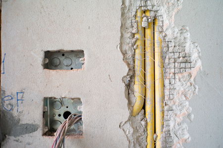 Abstract texture and background of electrical system under installation inside the concrete wall in the house under construction.の写真素材