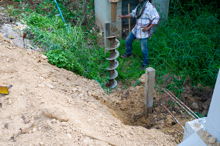 Landscape picture of workers drilling the soil ground by drilling machine. Drilling the hole for footing the reinforcement concrete poles.の写真素材