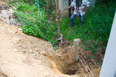 Landscape picture of workers drilling the soil ground by drilling machine. Drilling the hole for footing the reinforcement concrete poles.の写真素材