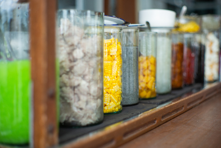 Selective focus of various kind of dessert topping in the glass jars