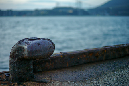 Selective focus of rusted steel post for seizing the ship at the pier