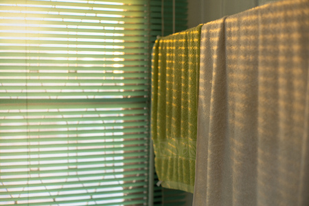 Texture and background of towels hanging on the hanger with light of sunset and shadowの写真素材
