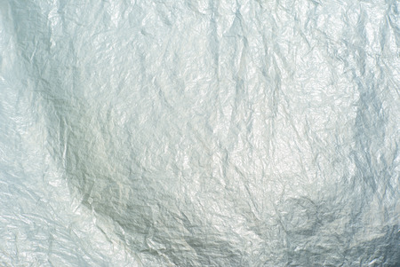 Abstract texture and background of wrinkled plastic sheet reflec to the light of sun