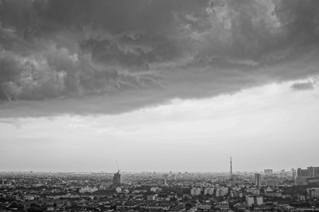 Monochrome landscape of city with crowd of building and residential area with rainy cloudの写真素材