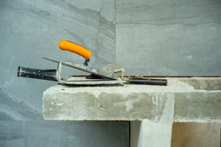 Closeup picture of dirty trowel for plastering the cement texture on the wall surfaceの写真素材