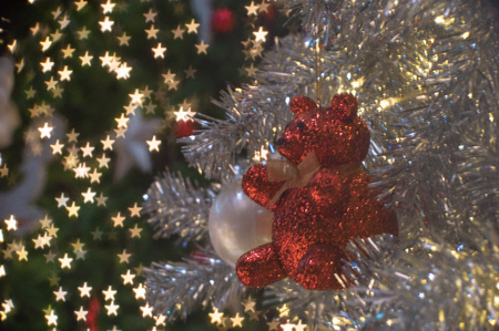 Abstract background of glittering bokeh lights with blurred ornament on the silver Christmas tree in...