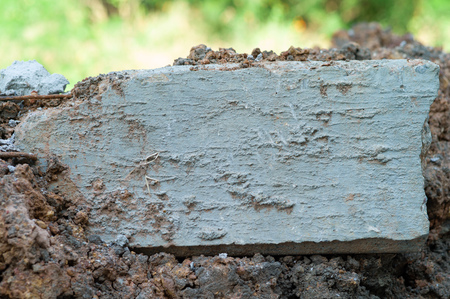 Closeup broken concrete structure with reinforcement steel lay on the soil ground at the construction siteの写真素材