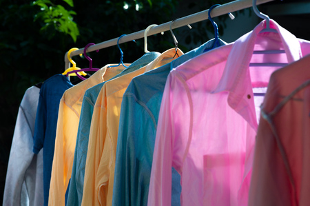 Colorful wet clothes hanging on the steel clothesline for drying by the heat of sun