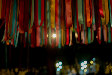 Abstract defocused colorful ribbons hanging from the roof for decoration in the celebration event
