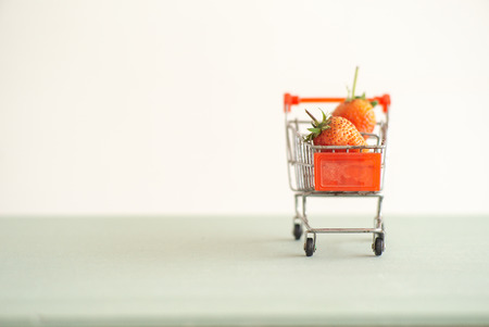 Closeup strawberries in the shopping trolley. Cart carrying the strawberry with the isolated backgroundの写真素材