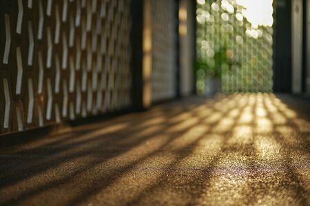Selective focus on cement floor of corridor reflects the light of sunset with blurred bokeh lights...