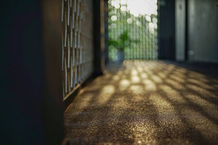 Selective focus on cement floor of corridor reflects the light of sunset with blurred bokeh lights...