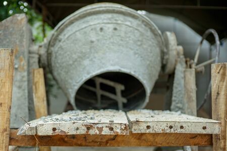 Selective focus on group of crashed stones on the steel plate with blurred concrete mixer at the construction siteの写真素材