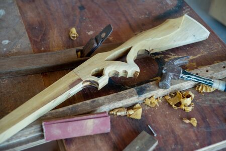 Selelctive focus on wooden toy in gun shape on electrical cutting machine at house under...