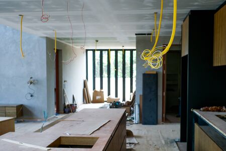 Selective focus on electrical wire hanging from ceiling with perpsective of house under constructionの写真素材