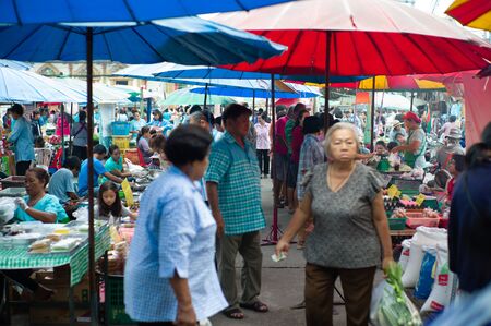 Ratchaburi, Thailand:August 12, 2019 - Crowd of people walk and buy the fresh food in morning flea market with defocused people in foreground. People lifestyle in morning in urban province of Thailandのeditorial素材